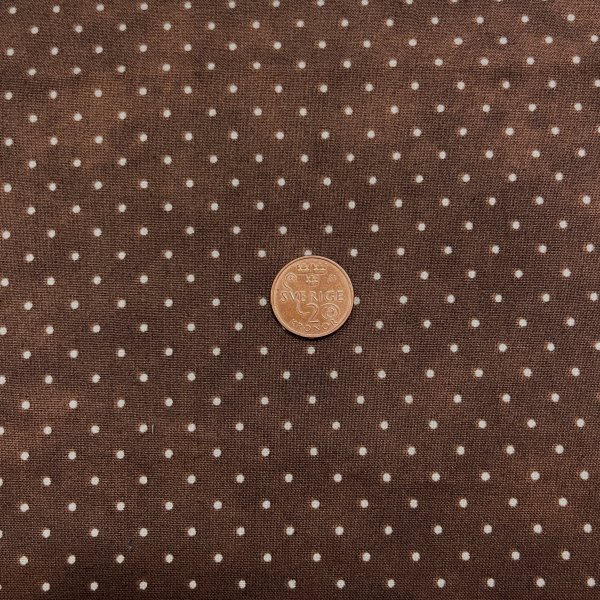 1505, brun med små vita prickar, tygbredd 110cm.